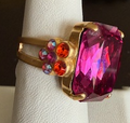MARIANA RING RAINBOW SHERBERT: 3/4" fuschia emerald cut stone, with orange and pink, yellow gold setting, adjustable band