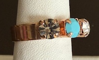 MARIANA RING ZANZIBAR: blue, black, clear, taupe 1/4" stones in rose gold setting, adjustable size band
